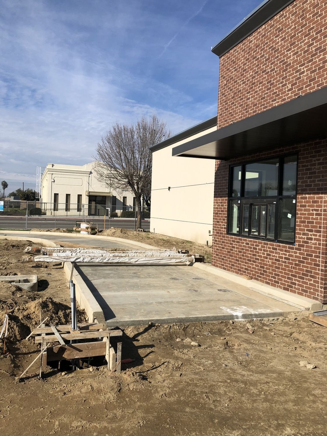 Crew pouring a new sidewalk along a street frontage