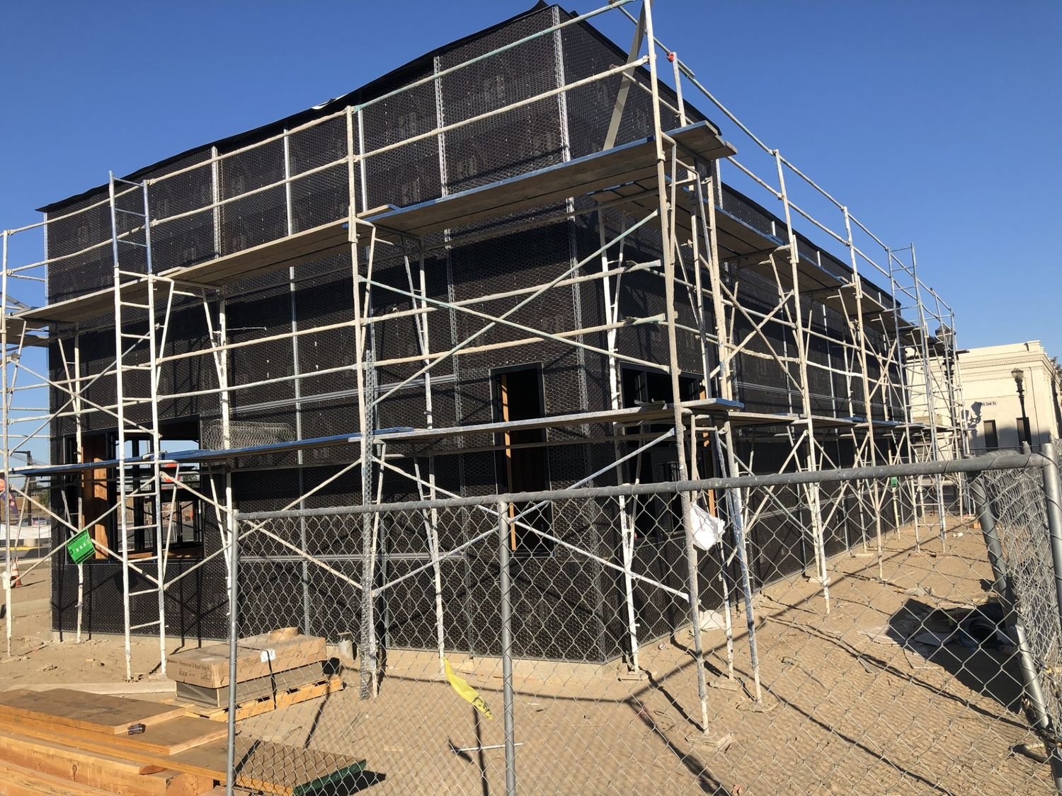 Two-storey commercial shell wrapped and scaffolded
