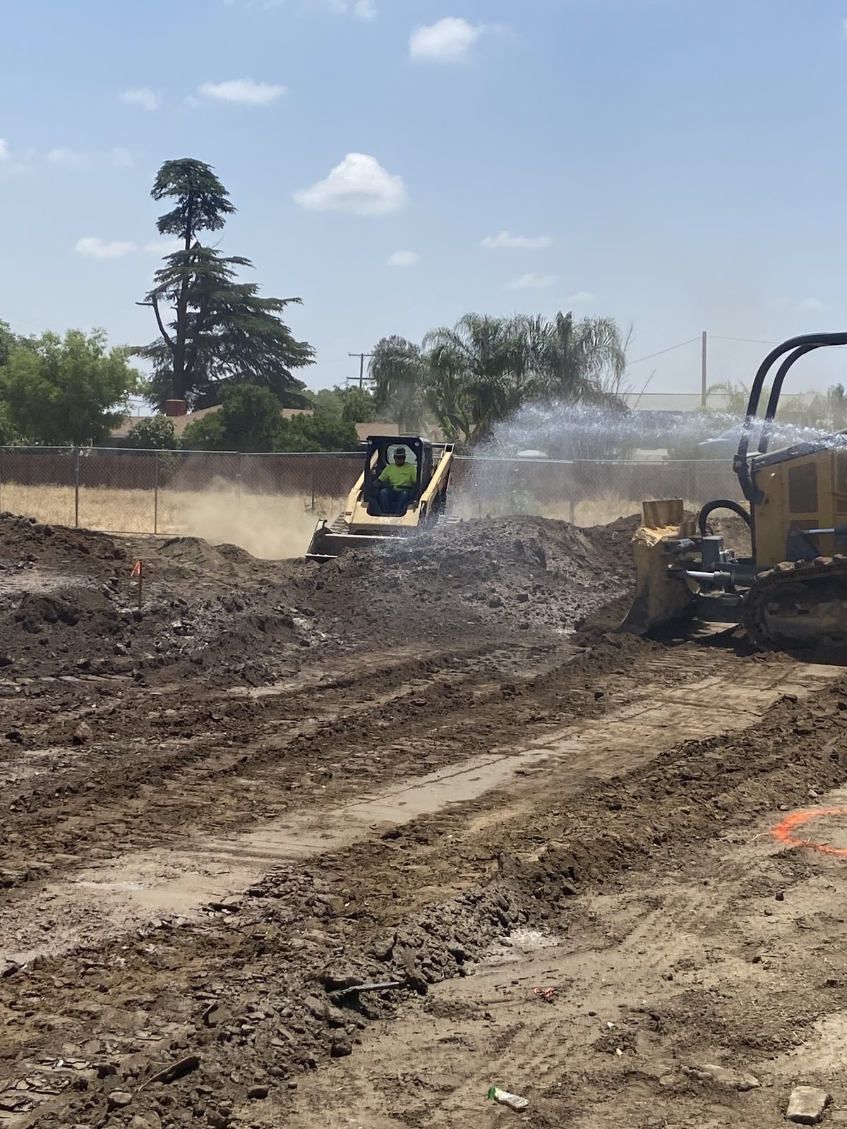 Excavator cutting and grading the site